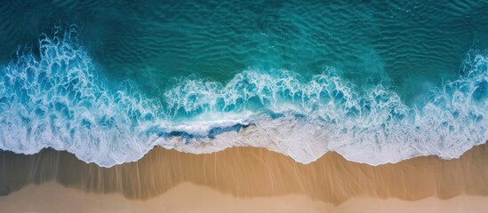 Aerial view of beach with waves washing over wet sand - obrazy, fototapety, plakaty