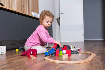 A little girl plays with a toy train