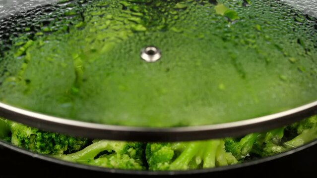 Zoom frame green broccoli frying on a pan. Healthy food, vegetarian cuisine