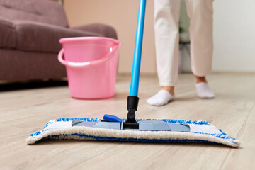 caucasian woman cleaning and mopping floor at living room, daily housekeeping , close-up