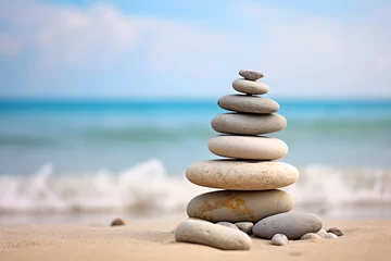 Poster Rock balancing. Stones piled in balanced stacks in front of blurry beach background with copy space © Firn