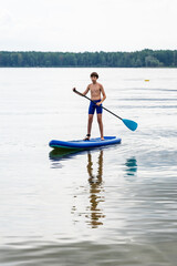 Teenager and SUP board. Active recreation on the Senftenberg lake. Federal land of Brandenburg....