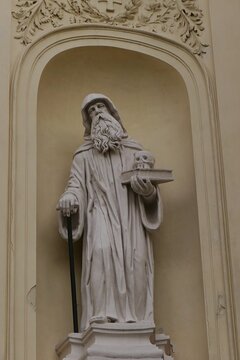 Baroque statue of hooded bearded saint with book and skull in his left hand and walking stick in the right. Located on front wall of Church Of Saint Peter and Paul, benedictine monastery in Rajhrad.