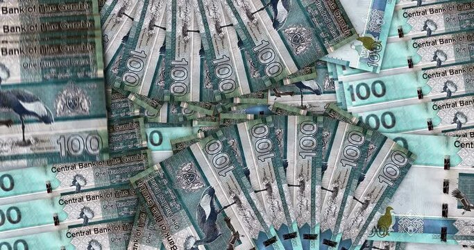 Gambia money Gambian dalasis banknotes in a cash fan mosaic pattern loop. 100 GMD notes. Abstract concept of bank, finance, economy seamless and looped design background.