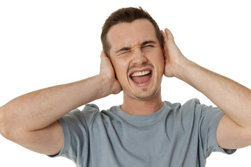Naklejka premium caucasian man in t-shirt covers ears with hands on white background