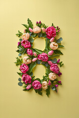 Number "8" made of peonies and tulips isolated on pastel yellow background. 8 march, international womans day concept