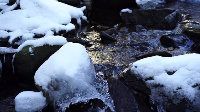 Water from melting ice flowing down a stream in Laterns, Austria