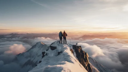 Fotobehang Two climbers on a mountain summit at sunrise, overlooking a sea of clouds, embodying adventure and achievement. © tashechka