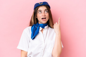 Airplane stewardess caucasian woman isolated on pink background thinking an idea pointing the finger up