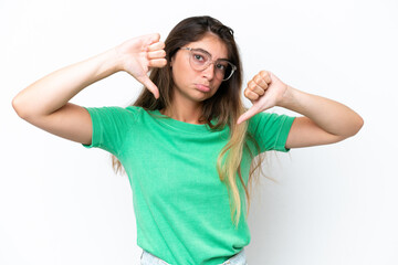 Young caucasian woman isolated on white background showing thumb down with two hands