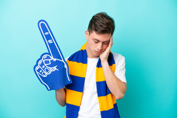 Young sports fan man isolated on blue background with headache