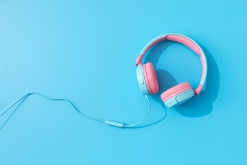 Bright wired headphones on a blue background. Music and technology. Copy space