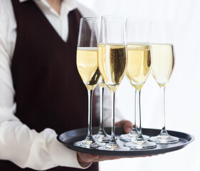 Professional male waiter in uniform serving champagne. DOF.