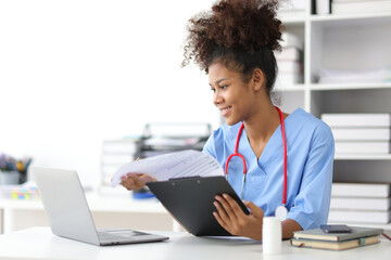 African female doctor in office doing paperwork and writing prescriptions. - obrazy, fototapety, plakaty