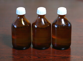 Three small brown glass bottles of medicine