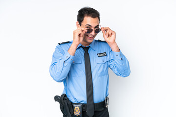 Young police caucasian man isolated on white background with glasses and surprised