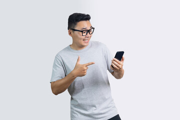 Portrait of smile happy man is pointing on smartphone standing against white background