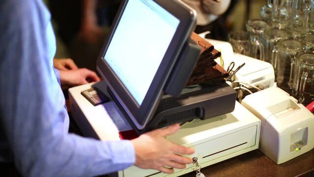 Cashier on cashdesk gives change and issues a cash register