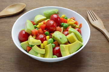 close up view of avocado salad with sesame soy sauce in a bowl on wooden table. homemade style healthy food concept.