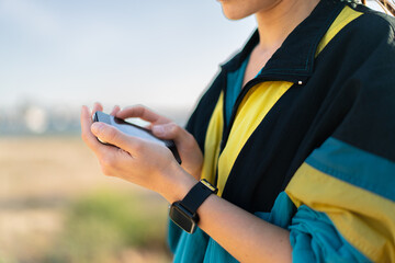 Young woman at outdoors wearing sport wear and listening music with phone