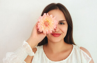 Obraz na płótnie Canvas Young woman with flower near eye