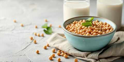 Soybeans in Bowl with Glass of Soy Milk, copy space. A nutritious setup of soybeans, fresh soy milk on a white textured table background.