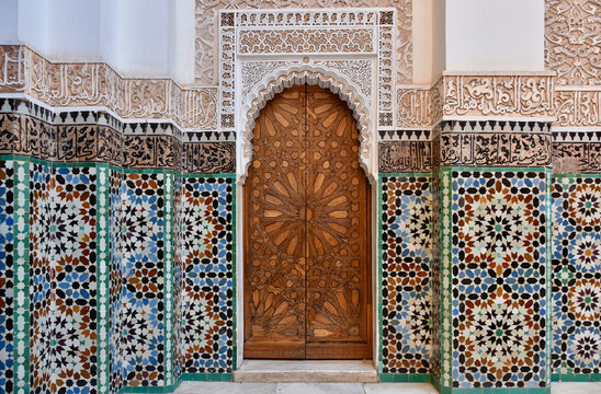 Moroccan Mandala Tile Patterns and Carved Wooden Double Door with Keyhole Frame in Marrakech