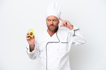 Chef man holding an avocado isolated on white background having doubts and thinking