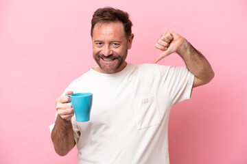 Middle age caucasian man holding cup of coffee isolated on pink background proud and self-satisfied
