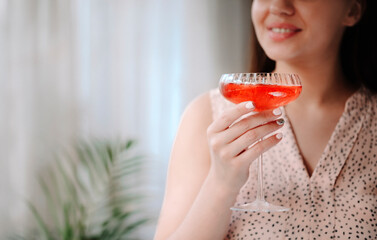 Crop woman enjoying cocktail at home