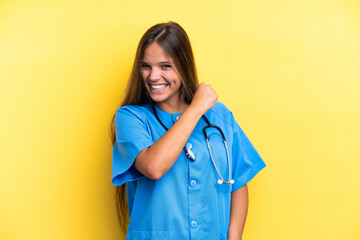 Young nurse caucasian woman isolated on yellow background celebrating a victory