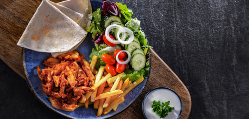 Kebab served with french fries and vegetables