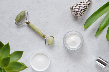 skin care products on the table jade facial massager and cream