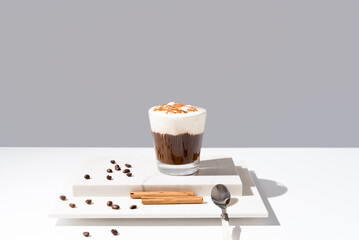 Café irlandés con crema batida y canela sobre fondo gris