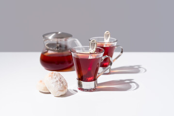 Dos tazas de té rojo con pasteles y dulces sobre mármol	