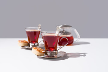 Dos tazas de té rojo con pasteles y dulces sobre mármol	