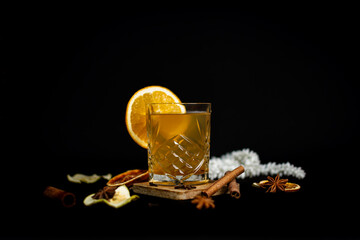 Winter cocktail with honey and orange on a black background