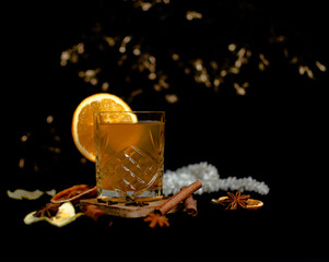 Winter cocktail with honey and orange on a black background