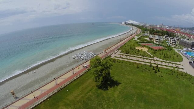 Sea beach with people get rest near territory of hotels 