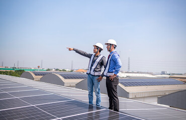 Engineers walking on roof inspect and check solar cell panel by hold equipment box and radio...