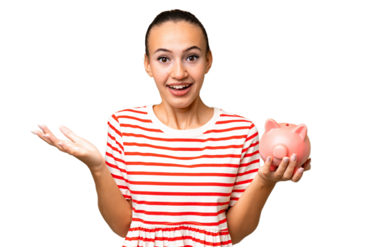 Young Arab woman holding a piggybank over isolated background with shocked facial expression