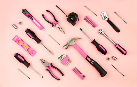 Renovation tools for a girl. Men's work is done by woman's hands. Strong, but beautiful. Pink construction equipment  on pink background. Woman's or girl's power.  Top view flat lay