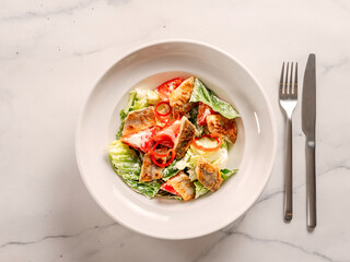 Delicious salad with fried baked smelt fish. Fried fish salad with fresh green lettuce, tomatoes, bell pepper. Ketogenic, keto or paleo diet lunch bowl. Ideas and recipe for fish lunch dishes menu
