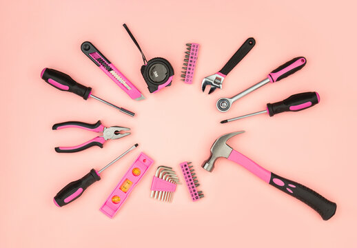 Renovation tools for a girl. Men's work is done by woman's hands. Strong, but beautiful. Pink construction equipment  on pink background. Woman's or girl's power.  Top view flat lay