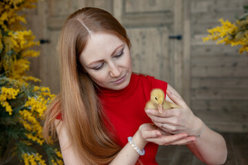 girl with long red hair in a red dress with a small yellow duck in her hands