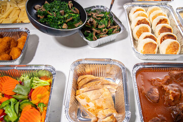 Batch Cooking Meal Prep concept. Several types of side dishes: cereals, pasta, pasta, cooked and fresh vegetables, meat, chicken, nuggets, breakfast pancakes and fruit in food containers 