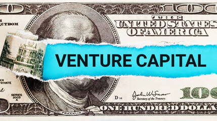 Venture Capital. The word Venture Capital in the background of the US dollar. Investment in...