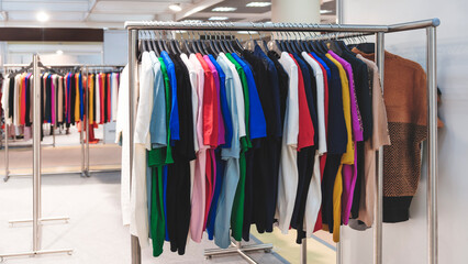 Multicolor family clothes on hangers in store