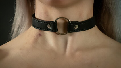 A young blonde with a choker and abrasions on her neck. Traces of violence. BDSM concept. Dramatic photo. Horizontal Wide Banner