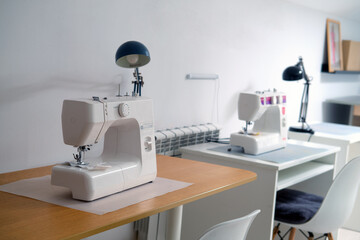 Sewing machine on the table in the sewing workshop. Sewing accessories.